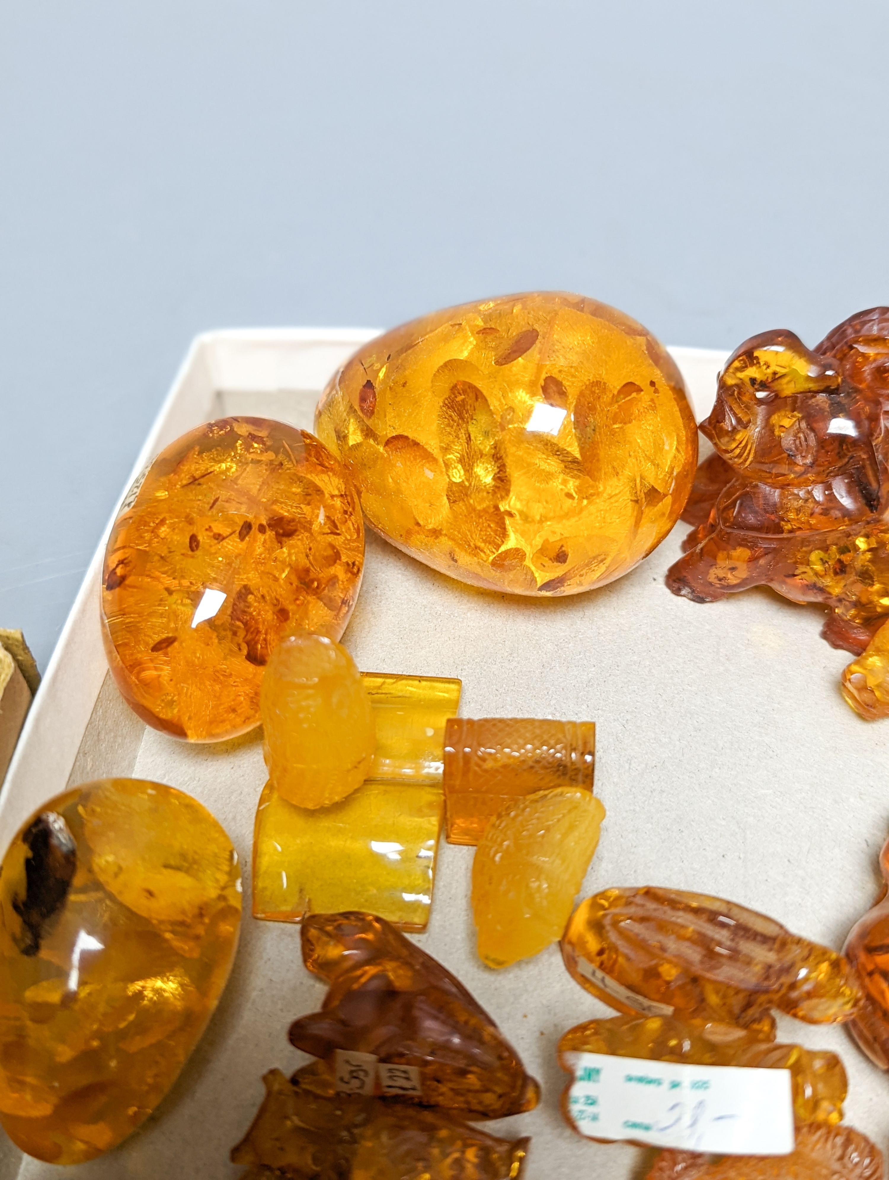 A mixed collection small carved amber wares including dice, eggs and cigarette holders, etc.